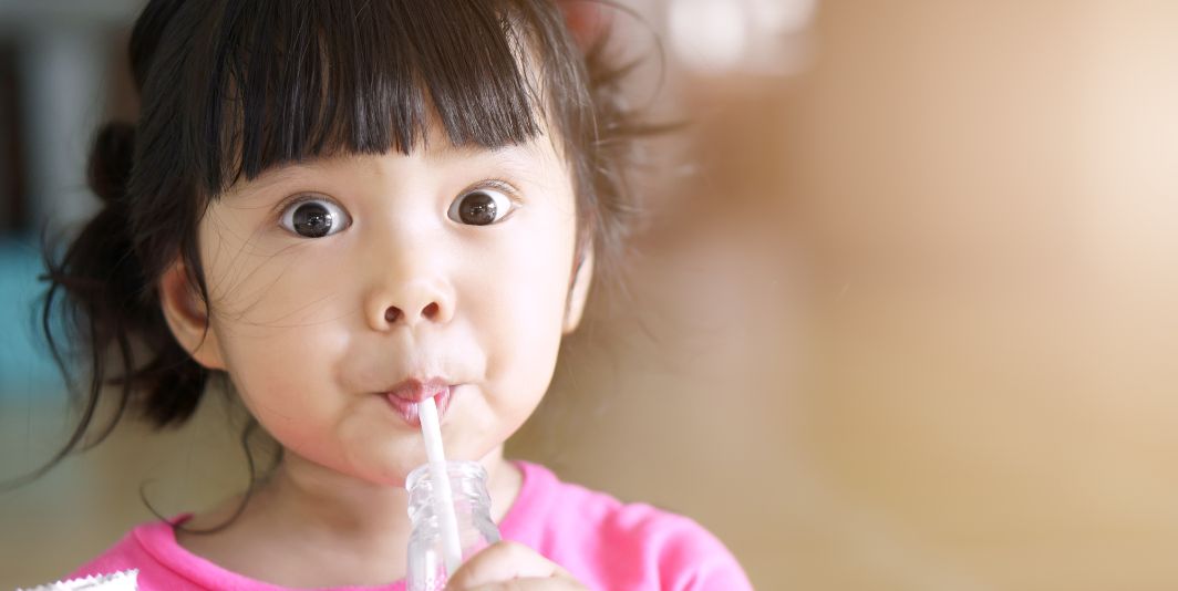 Young girl drinking something of a straw