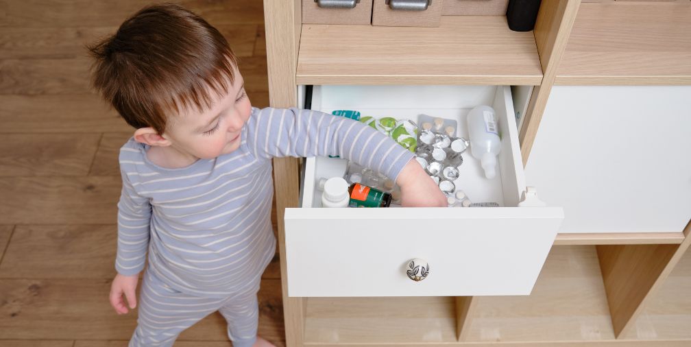 Toddler reaching into medicine drawer 