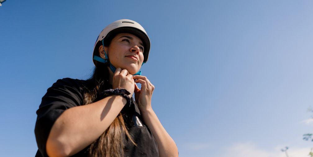 woman putting on a bike helmet 